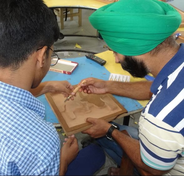 teacher teaching wooden craft to deaf student